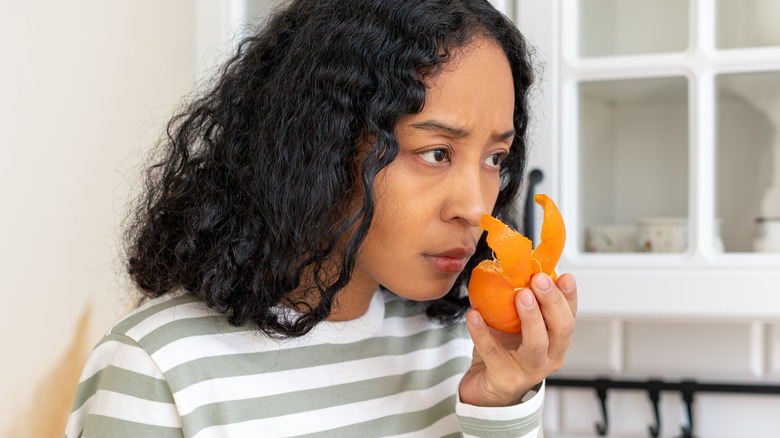 woman smelling orange peel