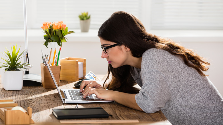 woman sitting at desk slouching