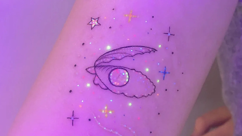 glow-in-the-dark clam and pearl tattoo