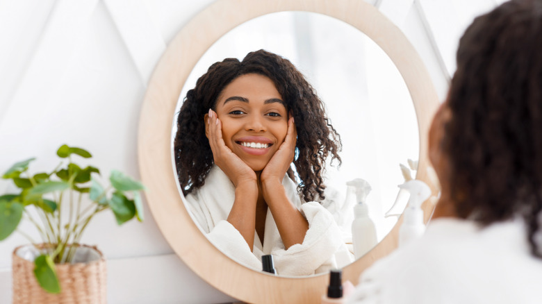 Woman admires reflection in mirror