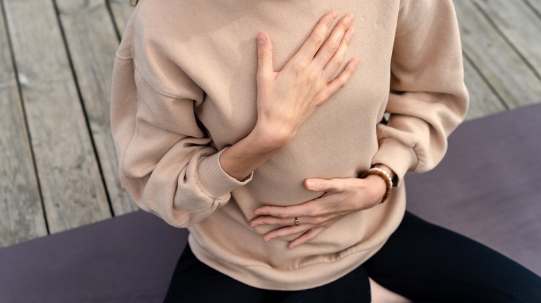 Woman with hands on heart and stomach