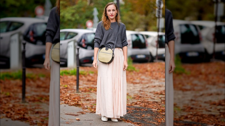 A woman wearing a sweater over a dress