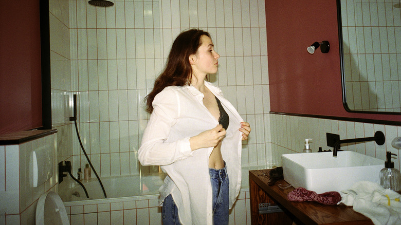 A woman buttoning up her top