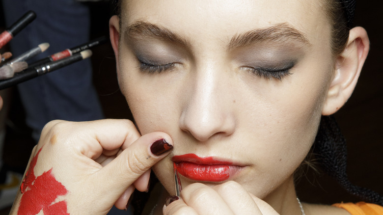 red lipstick application with brush