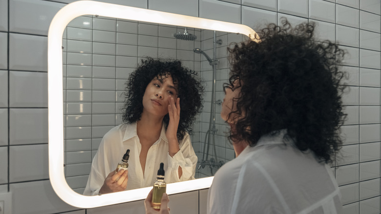 woman applying face serum