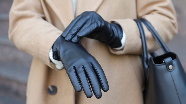 Close-up of model's hands with black leather gloves
