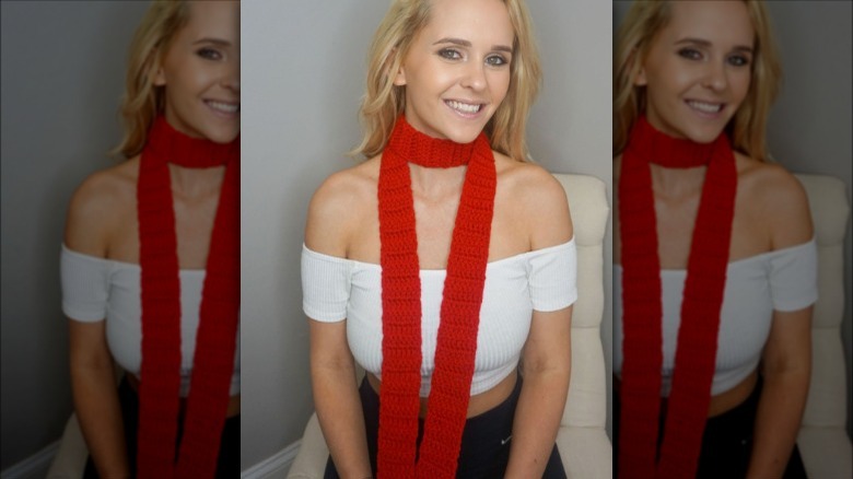 a woman wearing a red skinny scarf