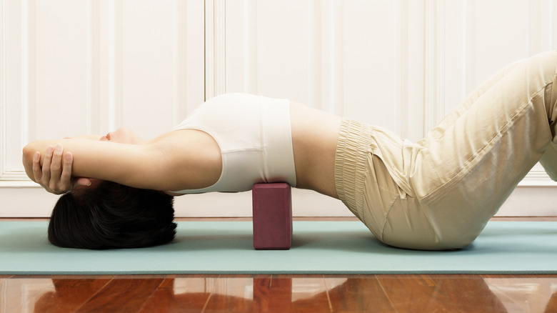 Woman doing yoga with block