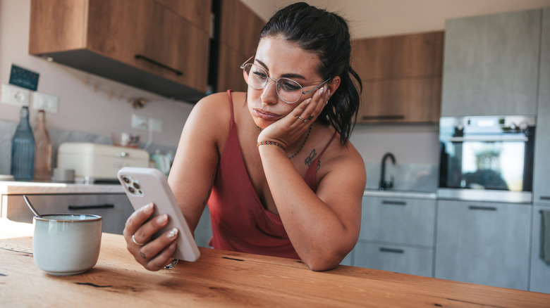 Woman looking at phone upset