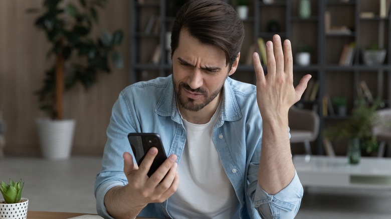 frustrated white man looking at phone