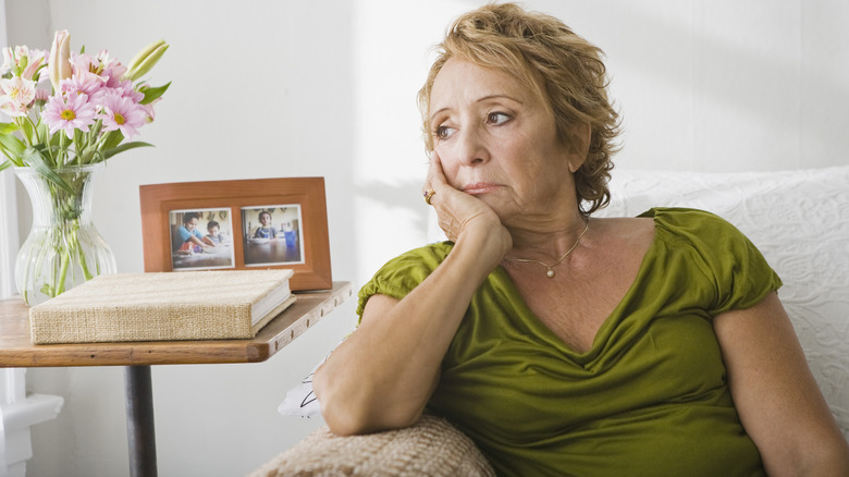 Woman sitting, appearing worried