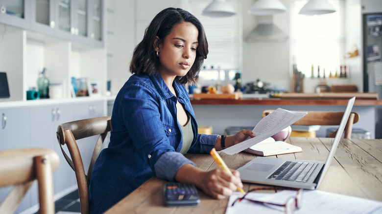 Woman doing paperwork in her kitchen