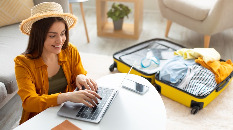 Woman next to open suitcase 