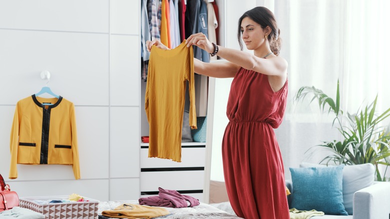 woman looking at clothes in closet