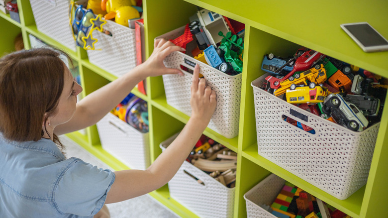 woman organizing childrens toy bin