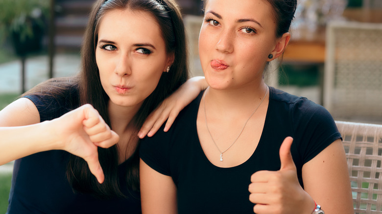 Women giving thumbs up and down