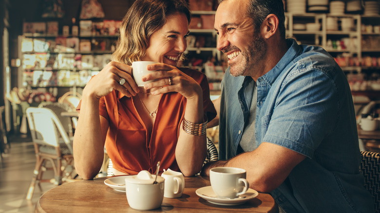 Woman and man smiling with mugs
