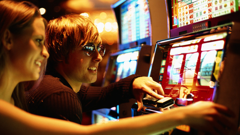 Couple gambling on slot machines