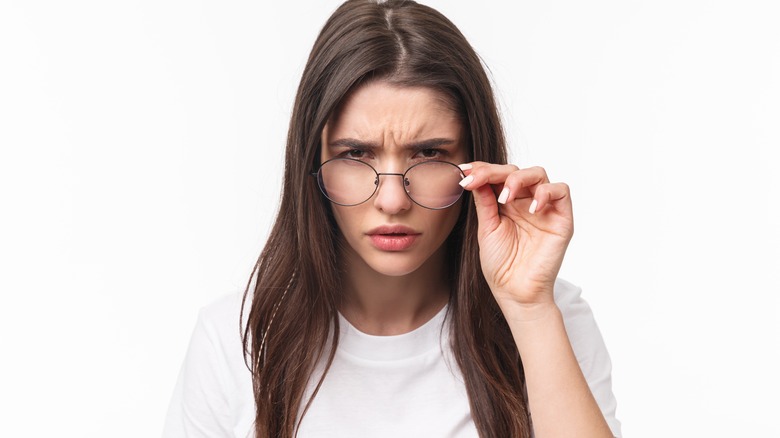 woman peering over glasses