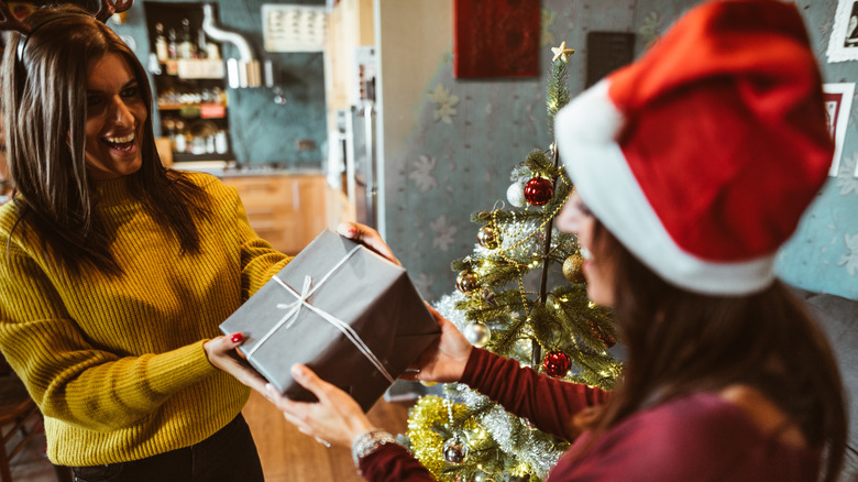 Woman giving gift in Santa hat