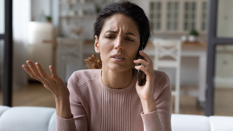 Disappointed woman talks on phone