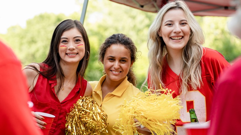 Three girlfriends at sporting event