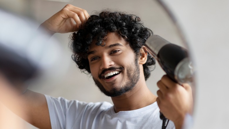 Indian man blowdrying curly hair