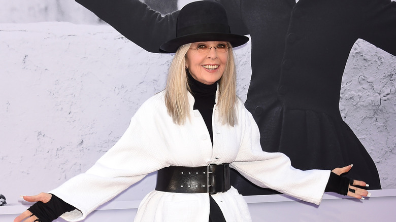 Diane Keaton in a white coat and black belt