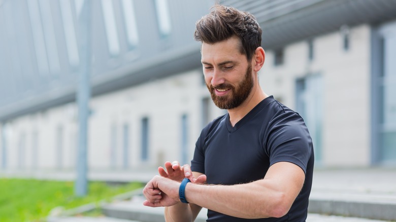 young man looking at his fitness watch