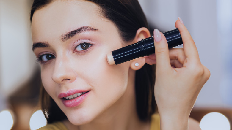 Woman putting on stick highlighter