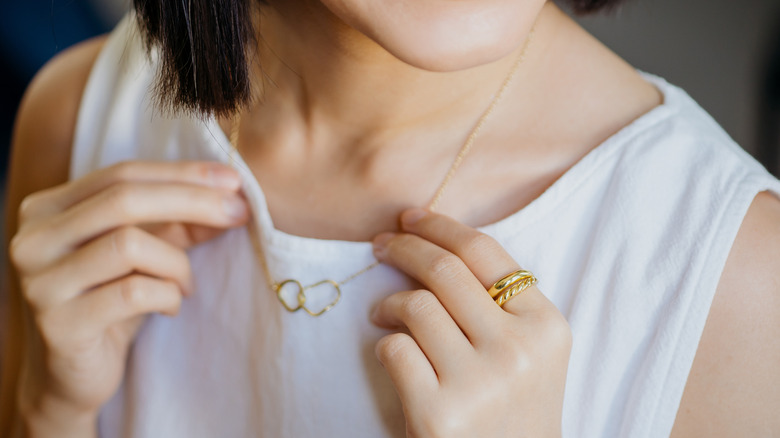 girl wearing gold necklace and rings