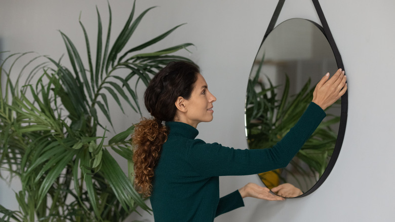 woman hanging a mirror