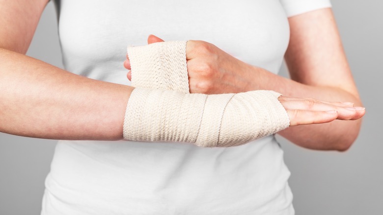 Woman wrapping a bandage around her arm