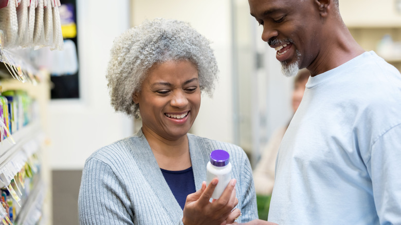 african american woman man reading label together in pharmacy