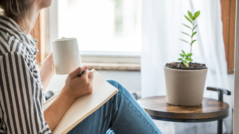 Woman writing with coffee