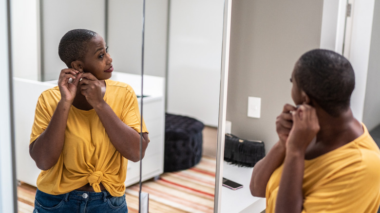 woman adjusting earrings