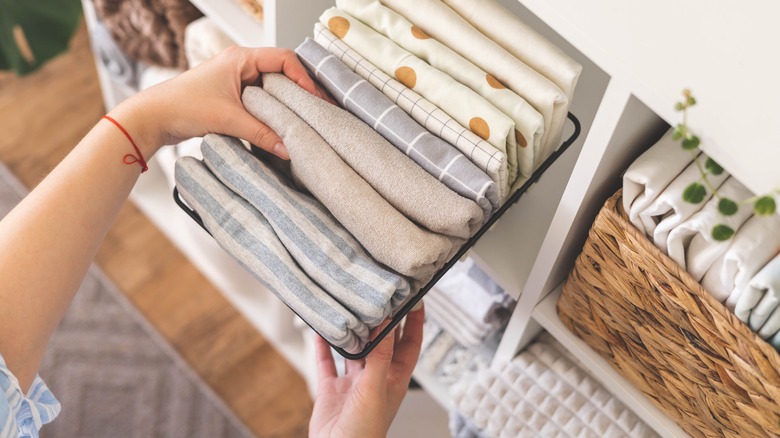 Woman taking pillowcases from shelf