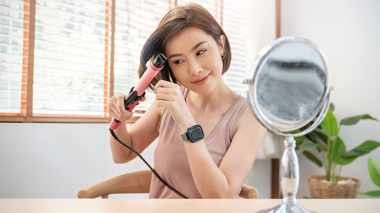 Woman using curling iron