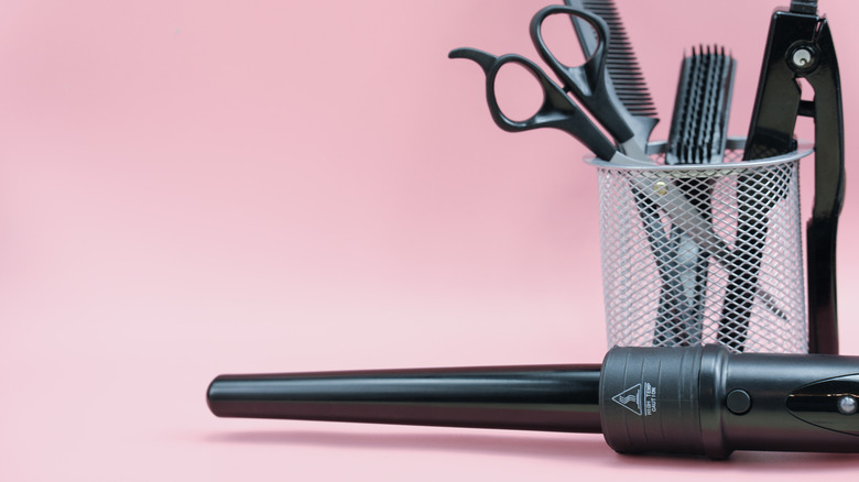 hairstyling tools against pink background