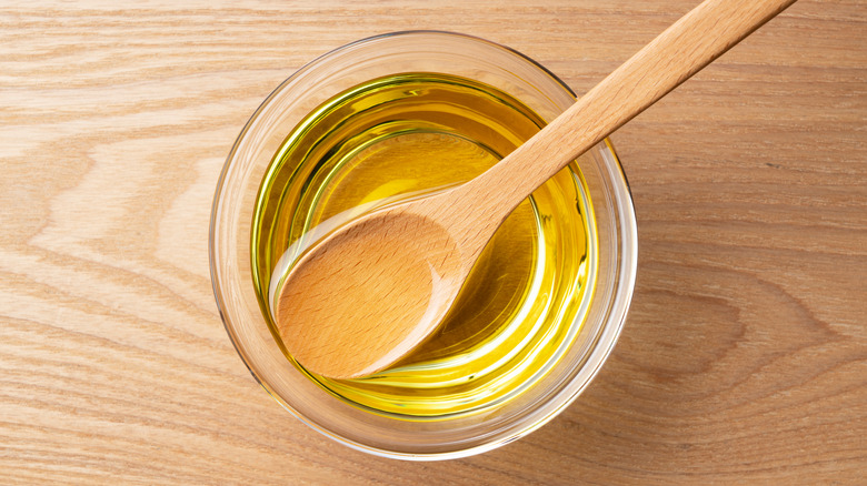 canola oil with wooden spoon