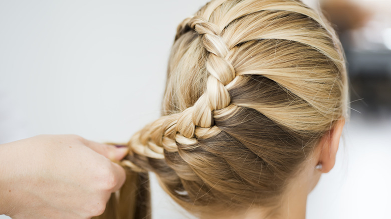 person braiding a woman's hair 