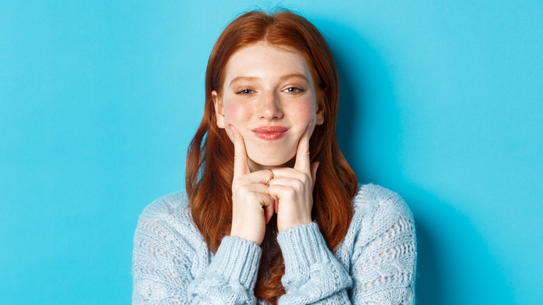 redheaded girl poking dimples