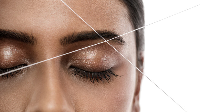 Woman having eyebrows threaded