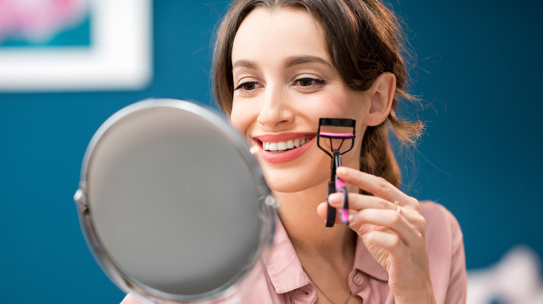 model holding an eyelash curler