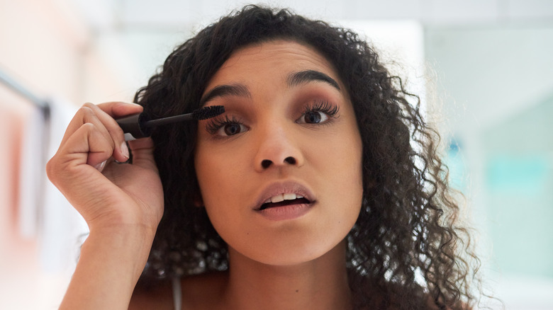 Woman applying mascara