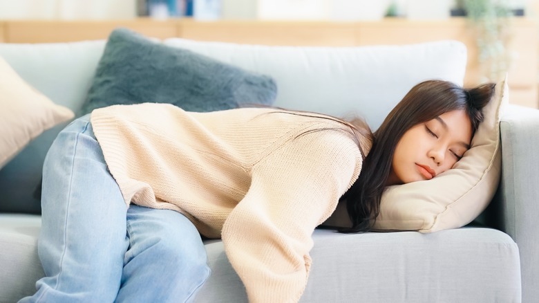 fatigued woman sleeping on couch