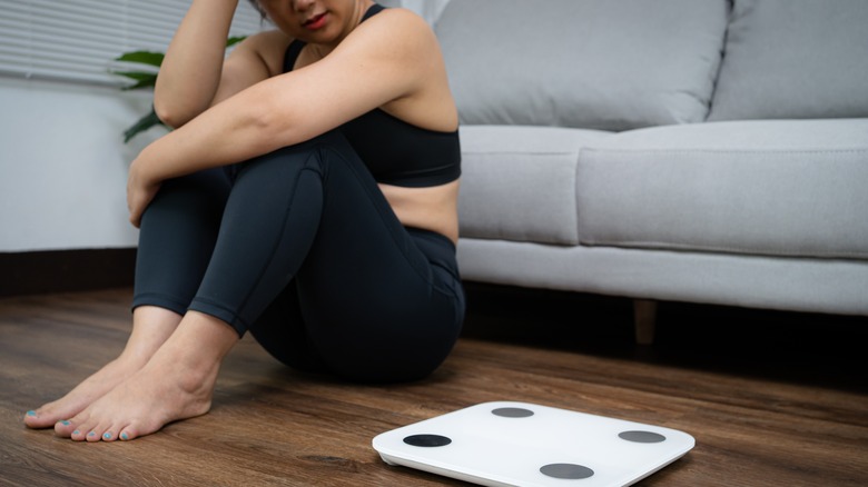 Woman sitting next to scale