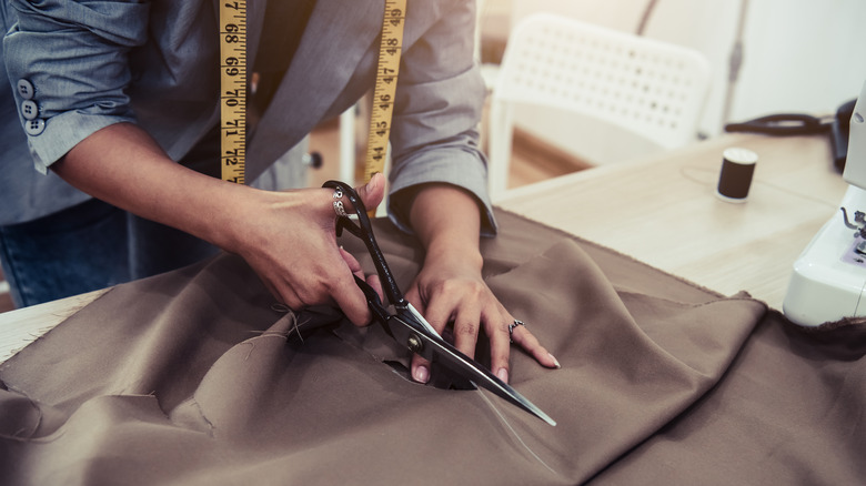 A tailor cutting fabric