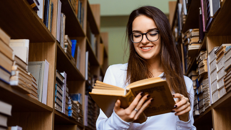 woman with glasses reading book