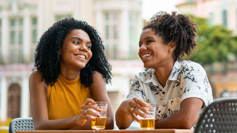 smiling women drinking outside